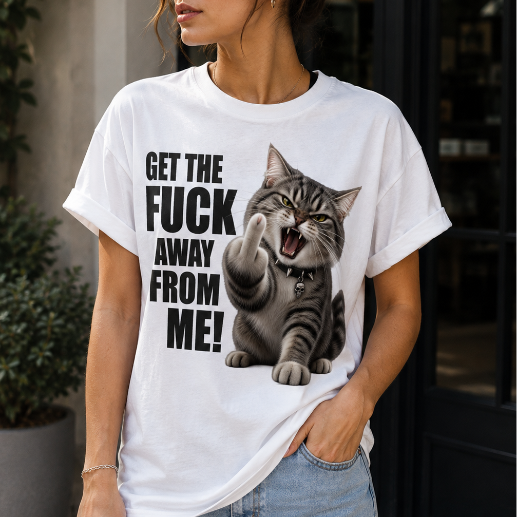 A woman wearing a white graphic t-shirt with a black text print and a tabby cat illustration, paired with light blue jeans, standing in front of a storefront.