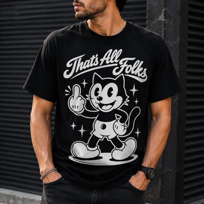 A man wearing a black graphic t-shirt with a white retro cartoon cat design and the text 'That's All Folks'. He is wearing black sunglasses and dark jeans, standing in front of a dark gray corrugated metal wall.